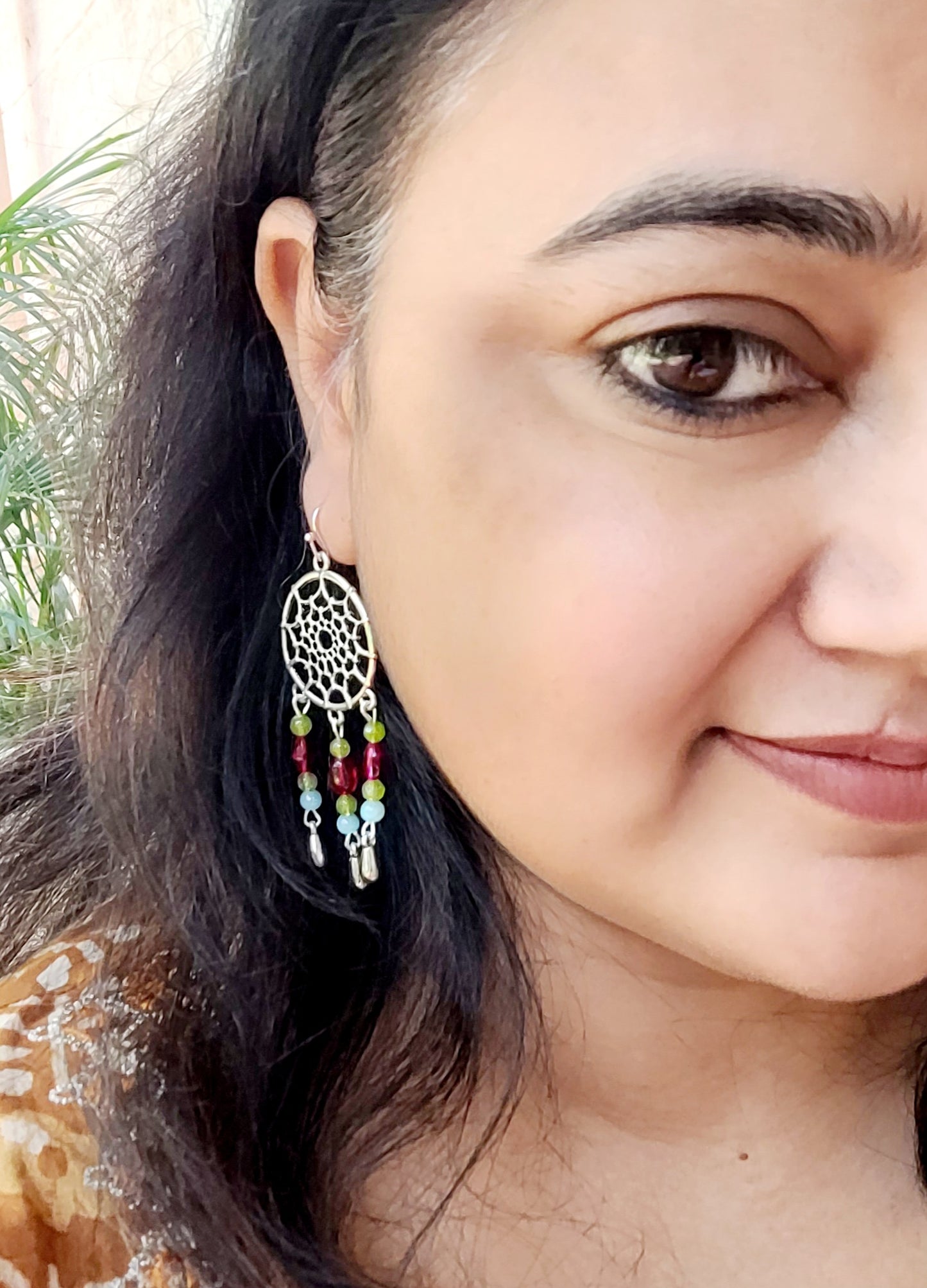 silver dreamcatcher earring with colorful beads.