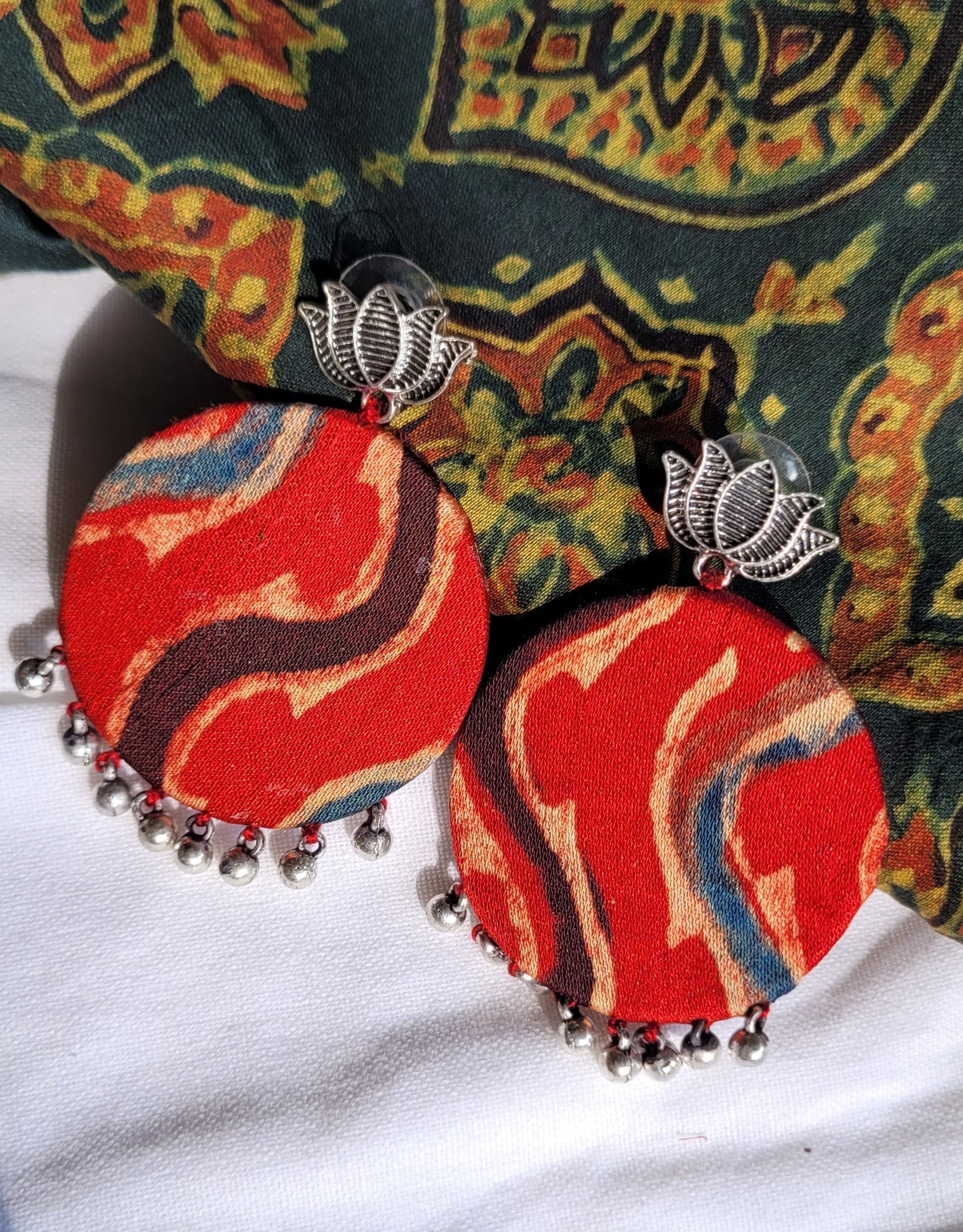 Colorful earrings with red and blue patterns on a white background