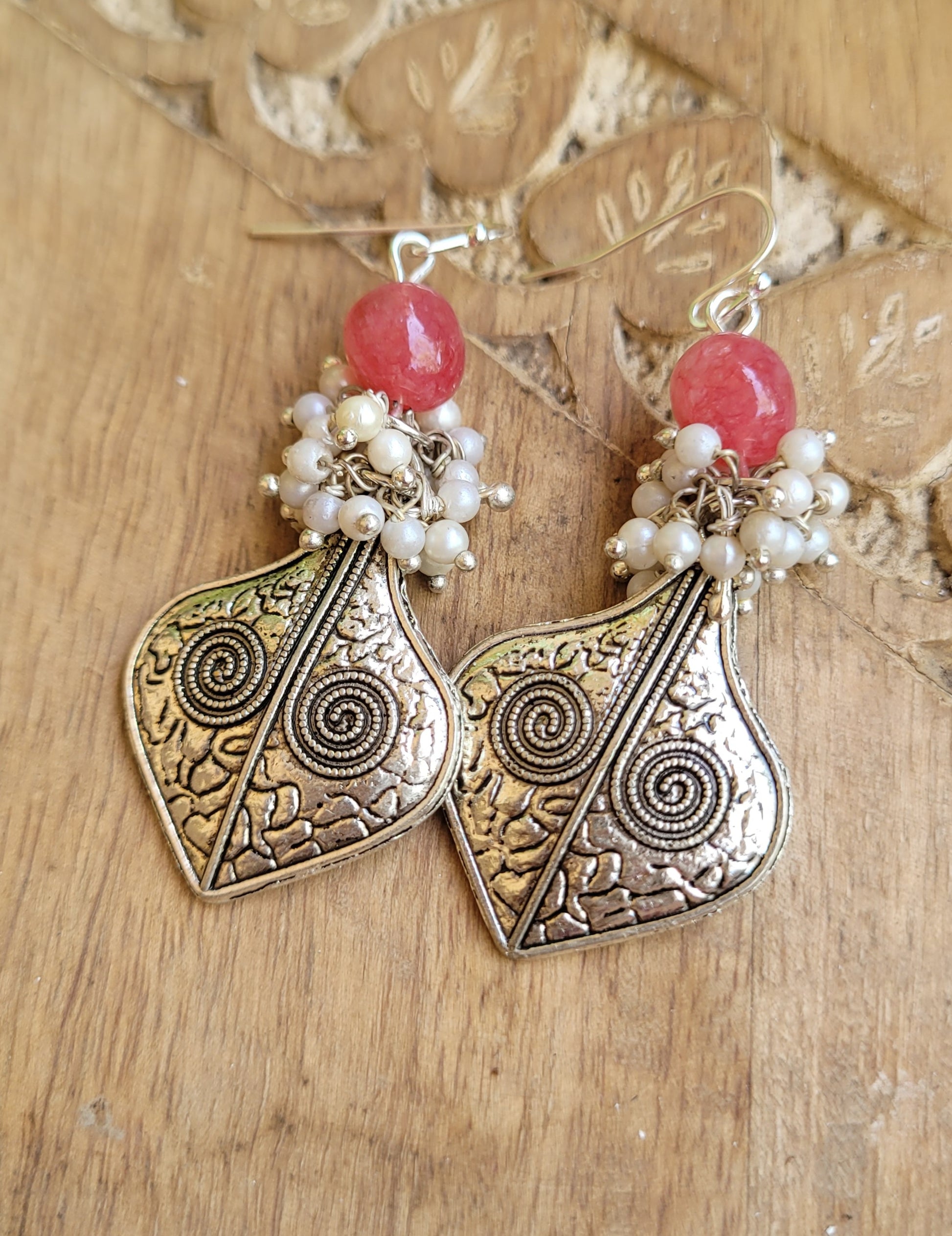 Ornate earrings with pink beads and pearl-like elements