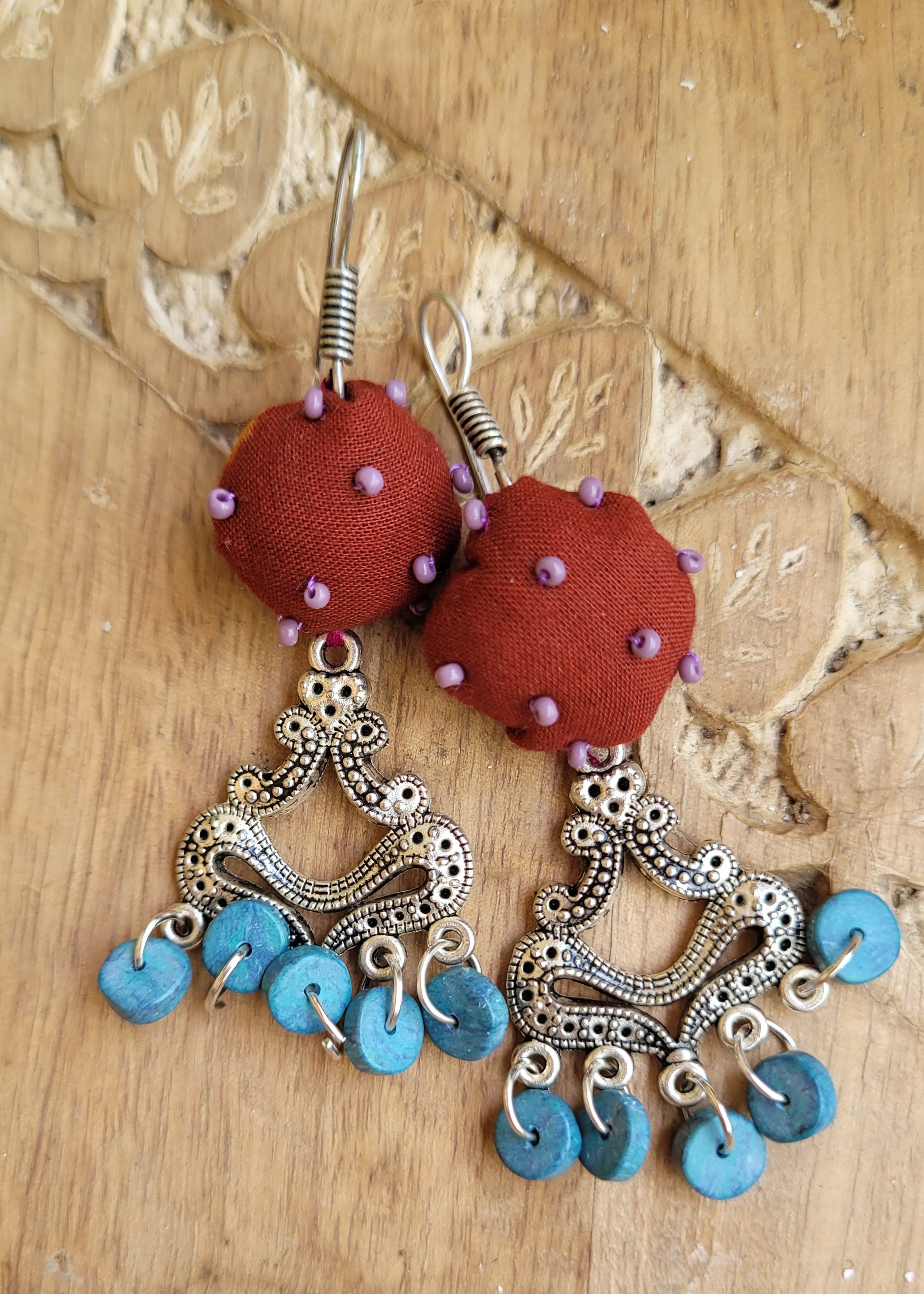 Pair of earrings with red fabric balls and blue beads 
