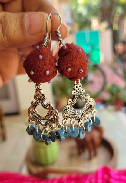 Ornate earrings with red fabric balls and blue beads 