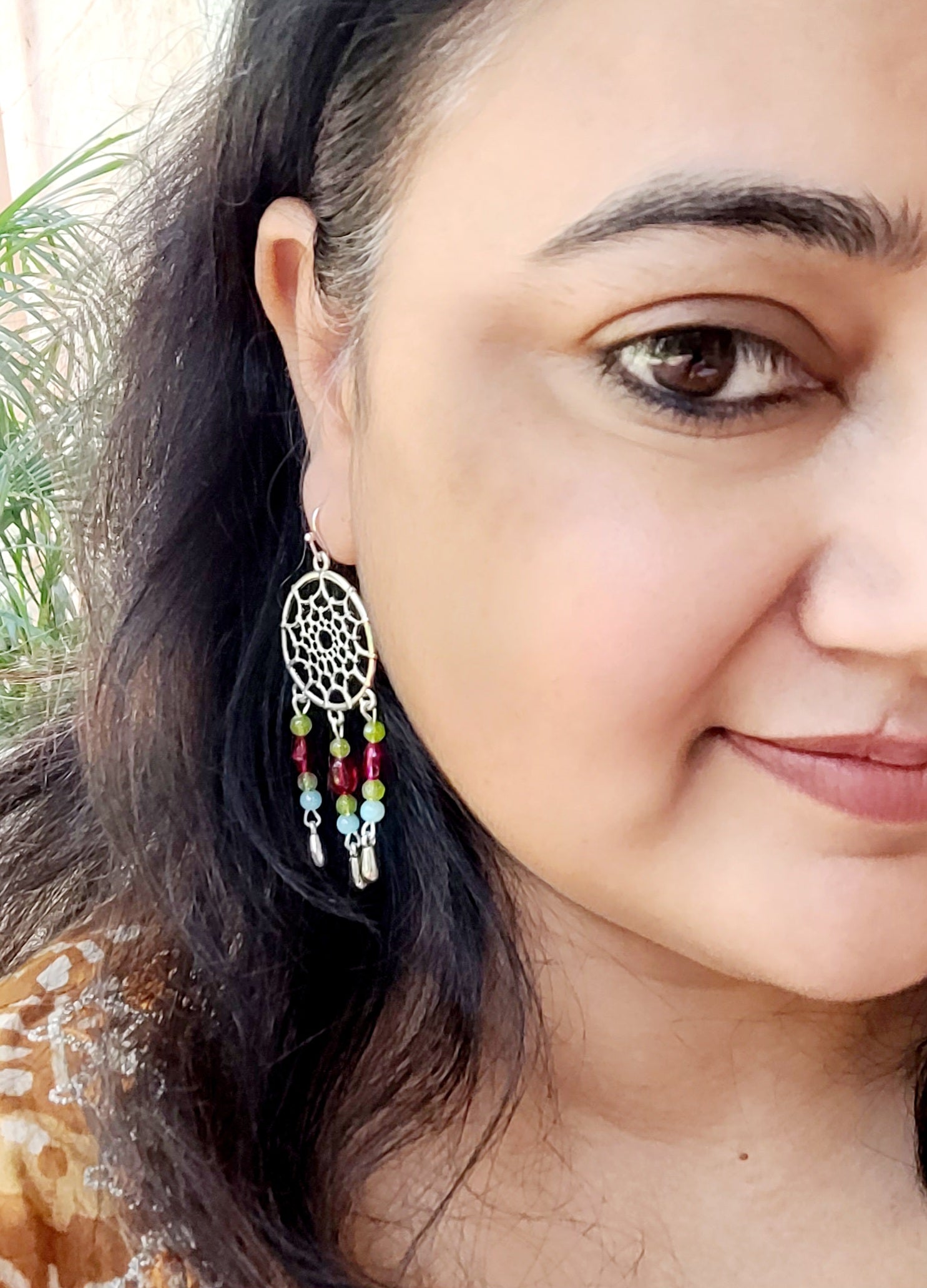  silver dreamcatcher earring with colorful beads.
