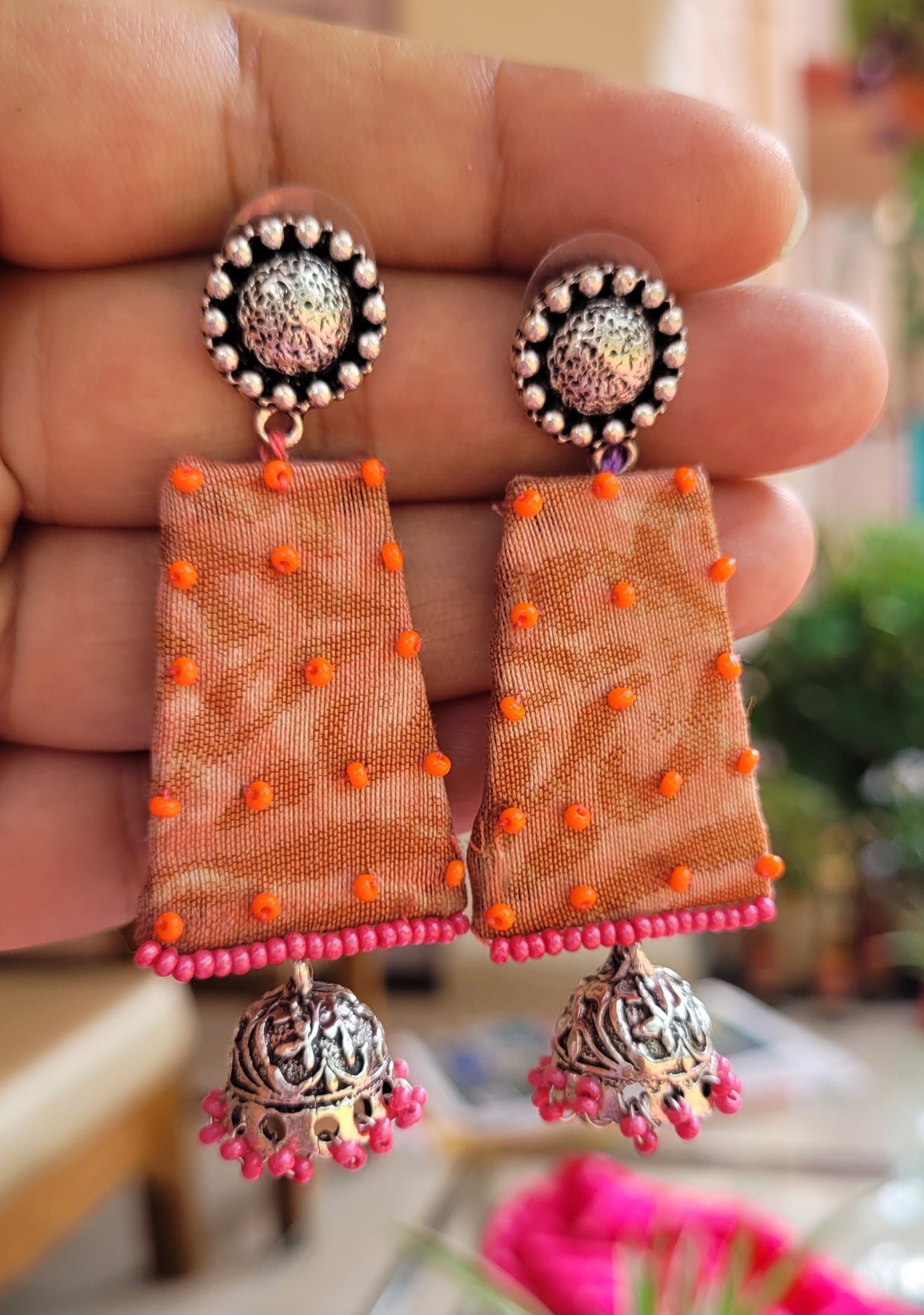 Decorative earrings with orange and pink elements.