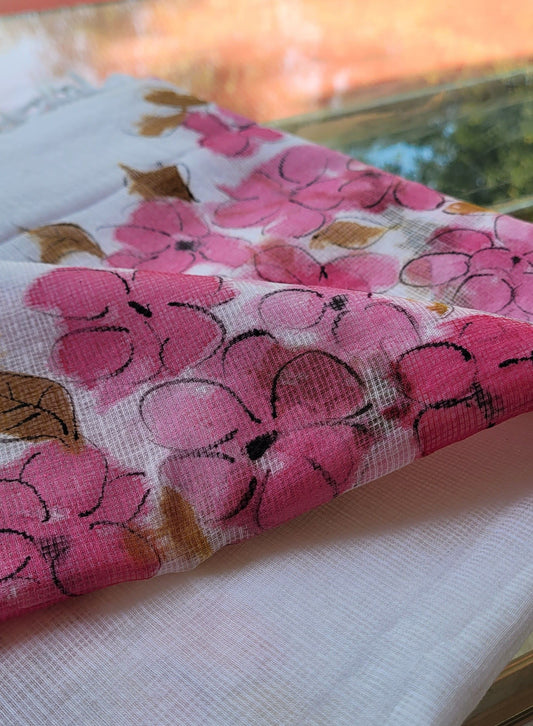 Floral-patterned fabric with pink flowers and green leaves on a white background