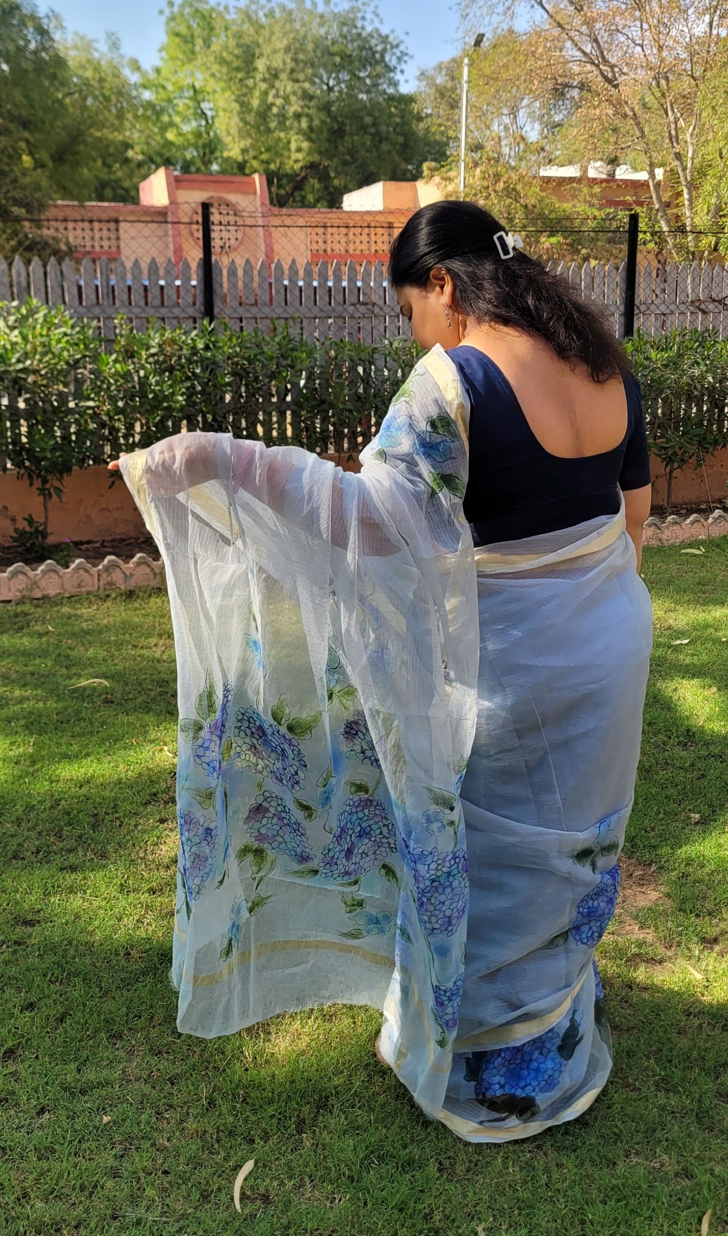 kota cotton saree with blue floral patterns in an outdoor setting.
