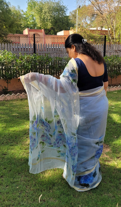 kota cotton saree with blue floral patterns in an outdoor setting.
