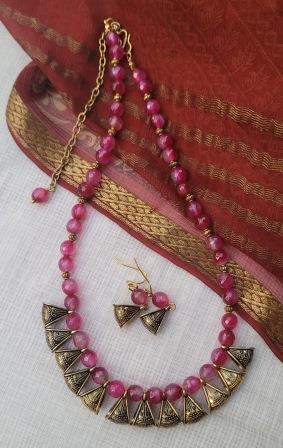Pink beaded necklace with gold accents and matching earrings