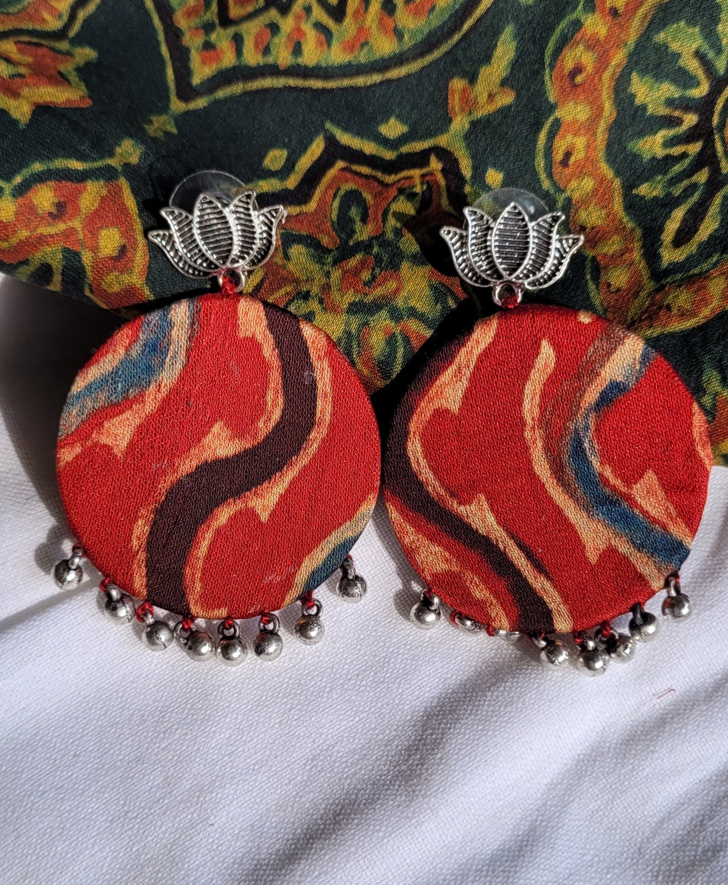 Pair of red fabric earrings with silver accents